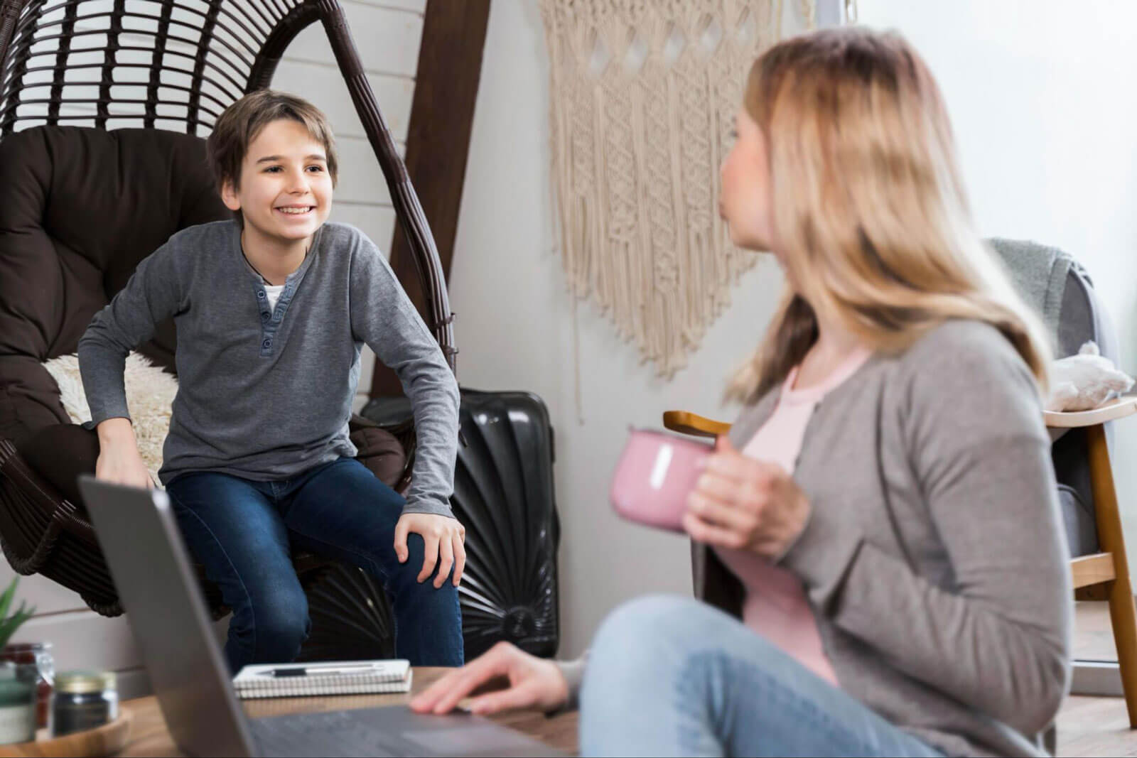 A teenage boy speaking with a counselor in a relaxed home setting, representing outpatient support, continued teen care, and recovery after residential treatment.