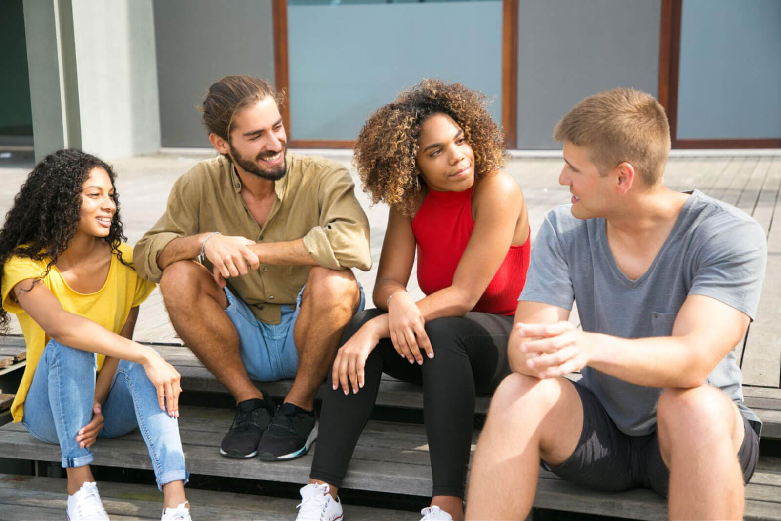 A diverse group of young adults sitting together outdoors and talking, representing peer connection, relapse prevention, emotional support, and long-term sobriety strategies for teens.