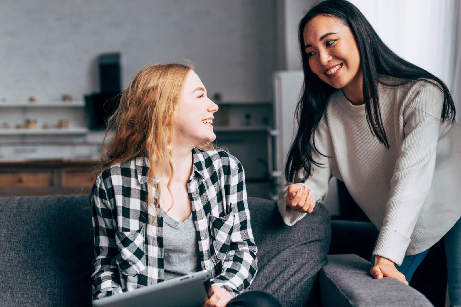 Two teenage girls having a supportive conversation while holding smartphones, representing teen communication, emotional support, substance misuse awareness, and recovery guidance.